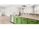 Kitchen with a stainless steel dishwasher, sink, and green lower cabinets at 10557 Bandera Mountain Ln, Las Vegas, NV 89166