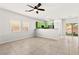 Bright living room with ceiling fan, tile floors, and adjacent to green kitchen at 10557 Bandera Mountain Ln, Las Vegas, NV 89166