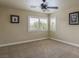 Neutral carpeted bedroom featuring a ceiling fan, two windows with white blinds, and art pieces on the walls at 11241 Pentland Downs St, Las Vegas, NV 89141