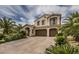 Charming two-story home displaying a tile roof, three-car garage, and lush palm trees at 11241 Pentland Downs St, Las Vegas, NV 89141
