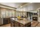 Open kitchen featuring dark wood cabinetry, granite countertops, and a dining area with fireplace at 11241 Pentland Downs St, Las Vegas, NV 89141