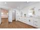 Bright bathroom with double vanity, framed mirror, and wood look floors at 1136 Casady Hollow Ave, Henderson, NV 89012