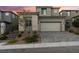 Beautiful two-story home showcasing stone accents, complemented by a paved driveway and desert landscaping at 12457 Sunset Sage Ave, Las Vegas, NV 89138