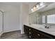 Bright bathroom featuring dual sinks with dark cabinetry and a shower/tub combination at 1453 Doggett Ave, Las Vegas, NV 89123