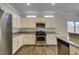 Kitchen features stainless steel appliances, granite countertops, white cabinets, and wood flooring at 1453 Doggett Ave, Las Vegas, NV 89123