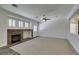 Spacious living room with stone fireplace, plush carpet, and a ceiling fan at 1453 Doggett Ave, Las Vegas, NV 89123