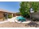 A backyard featuring a pool with a rock waterfall, surrounded by mature landscaping, hardscape, and patio space at 1453 Doggett Ave, Las Vegas, NV 89123