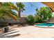 Backyard with a pool, patio area, block wall, mature trees, and landscaping create a serene outdoor living space at 1453 Doggett Ave, Las Vegas, NV 89123