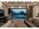 Living room featuring a view of a sparkling pool and outdoor living area with elegant, neutral-toned furniture at 15 Golden Sunray Ln, Las Vegas, NV 89135