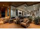 Covered patio with comfortable lounge seating overlooking lush landscaping and interior rooms through glass walls at 15 Golden Sunray Ln, Las Vegas, NV 89135
