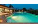 A luxurious pool with beautiful, modern landscaping and outdoor dining area is lit with underwater lighting at 15 Golden Sunray Ln, Las Vegas, NV 89135