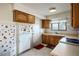 Functional kitchen with wooden cabinets, white appliances, and tile flooring offering a practical cooking space at 1716 Luning Dr, Las Vegas, NV 89106