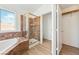 Bathroom featuring soaking tub, tiled shower with glass door, and access to walk-in closet at 1826 Monte Alban Dr, North Las Vegas, NV 89031