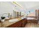 Bathroom featuring dual sinks, granite counters, a soaking tub, and windows at 1826 Monte Alban Dr, North Las Vegas, NV 89031