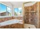 Bright bathroom featuring a soaking tub with tile surround and glass-enclosed shower at 1826 Monte Alban Dr, North Las Vegas, NV 89031