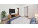 This staged bedroom includes a bed, plant, TV, and access to the hallway at 1826 Monte Alban Dr, North Las Vegas, NV 89031