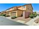 A modern townhome showcases a private garage, neutral stucco, and drought-tolerant landscaping at 2370 Via Firenze, Henderson, NV 89044