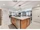 Modern kitchen island with seating, stainless steel dishwasher, and wooden cabinetry, open to the living area at 2370 Via Firenze, Henderson, NV 89044