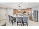 Bright kitchen featuring stainless steel appliances, a central island with seating, and elegant lighting fixtures at 2370 Via Firenze, Henderson, NV 89044