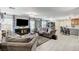 Bright, open living room with plush seating, light wood floors, and large TV, creating a comfortable and inviting space at 2370 Via Firenze, Henderson, NV 89044