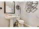 Stylish powder room with a pedestal sink, decorative mirror, and modern accents at 2370 Via Firenze, Henderson, NV 89044