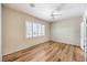 Comfortable bedroom with wood flooring, ceiling fan, and large window with plantation shutters at 2540 Binary Stars St, Henderson, NV 89044