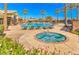 Community pool and hot tub with surrounding palm trees and lounge chairs at 2540 Binary Stars St, Henderson, NV 89044