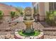 Outdoor fountain with a lion's head design surrounded by lush landscaping and a decorative fence at 2540 Binary Stars St, Henderson, NV 89044