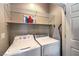 Well-organized laundry room with washer, dryer, shelving, and ironing board at 2540 Binary Stars St, Henderson, NV 89044