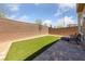 Low-maintenance backyard with artificial turf, a paved patio area, and privacy wall at 2732 Roman Palm Rd, North Las Vegas, NV 89086