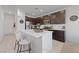 Modern kitchen featuring an island with seating, stainless steel appliances, and dark wood cabinetry at 2732 Roman Palm Rd, North Las Vegas, NV 89086