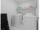 A well-lit laundry room features a modern washer and dryer set with overhead shelving at 2732 Roman Palm Rd, North Las Vegas, NV 89086