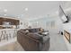 Open-concept living room with large sectional sofa, modern fireplace, and access to the kitchen area at 2732 Roman Palm Rd, North Las Vegas, NV 89086