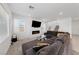 Bright living room featuring a large sectional sofa, electric fireplace, and staircase access at 2732 Roman Palm Rd, North Las Vegas, NV 89086