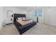 Well-lit main bedroom showcasing a tufted platform bed and two windows at 2732 Roman Palm Rd, North Las Vegas, NV 89086