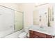 Bathroom featuring a bathtub with sliding glass doors and a vanity with a wooden cabinet at 2755 Asgard Ave, Las Vegas, NV 89121