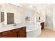 Bright primary bath featuring dual sinks, walk-in shower, and large soaking tub under a picture window at 2755 Asgard Ave, Las Vegas, NV 89121