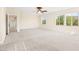 Large carpeted bedroom featuring a ceiling fan and access to other rooms in the house at 2755 Asgard Ave, Las Vegas, NV 89121