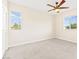 Bedroom featuring neutral carpeting, ceiling fan, and bright natural light from two windows at 2755 Asgard Ave, Las Vegas, NV 89121