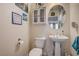Cozy half-bathroom with pedestal sink, toilet, and charming beach-themed decor at 2856 Trossachs St, Henderson, NV 89044