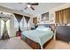 Bedroom with a ceiling fan, large window, carpet floors, and a bed with drawers at 2856 Trossachs St, Henderson, NV 89044