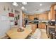 Open-concept kitchen with stainless steel appliances and wooden cabinets, next to dining area at 2856 Trossachs St, Henderson, NV 89044