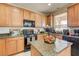 Bright kitchen with wooden cabinets, a granite countertop island, and modern appliances at 2856 Trossachs St, Henderson, NV 89044