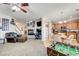 Open-concept living room with fireplace, comfortable seating, and connection to kitchen area at 2856 Trossachs St, Henderson, NV 89044