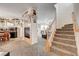 Open concept living space flows from a dining area featuring a fireplace and staircase at 2856 Trossachs St, Henderson, NV 89044