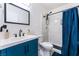 Bathroom featuring a modern sink vanity with blue cabinetry and a tiled shower with a dark curtain at 2990 Carnelian St, Las Vegas, NV 89121