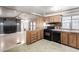 Well-lit kitchen featuring wood cabinets, granite counters, a black appliance package, and designer backsplash at 3471 Cape Cod Dr, Las Vegas, NV 89122