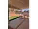 Covered patio area with chairs, small tables, an artificial lawn area and brick fence at 3644 Valley Dr, North Las Vegas, NV 89032