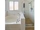 Bright bathroom featuring a soaking tub, separate shower, and tile surround at 3804 Wren Ct, North Las Vegas, NV 89032