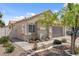 Exterior shot of a well kept house with neutral paint, desert landscaping, and a two car garage at 406 River Glider Ave, North Las Vegas, NV 89084